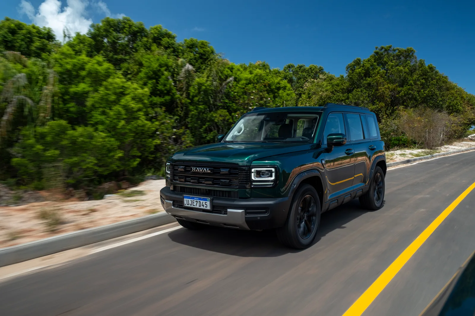 HAVAL H7 verde rodando em estrada litorânea